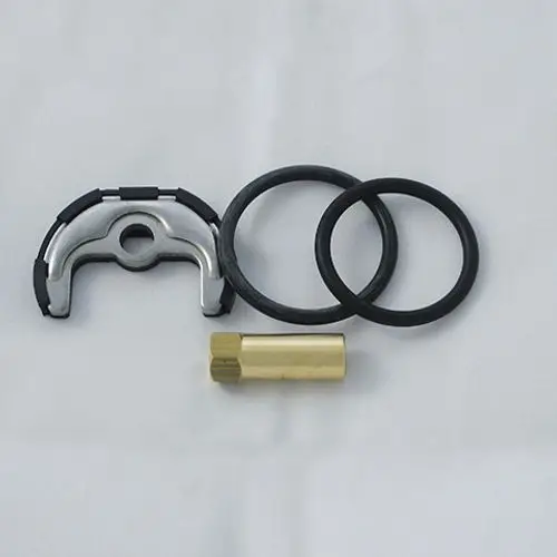 Befestigungssatz von Kludi, bestehend aus einer Metallklammer, zwei O-Ringen und einem goldfarbenen Einsatz. Gezeigt auf einer hellen Unterlage.